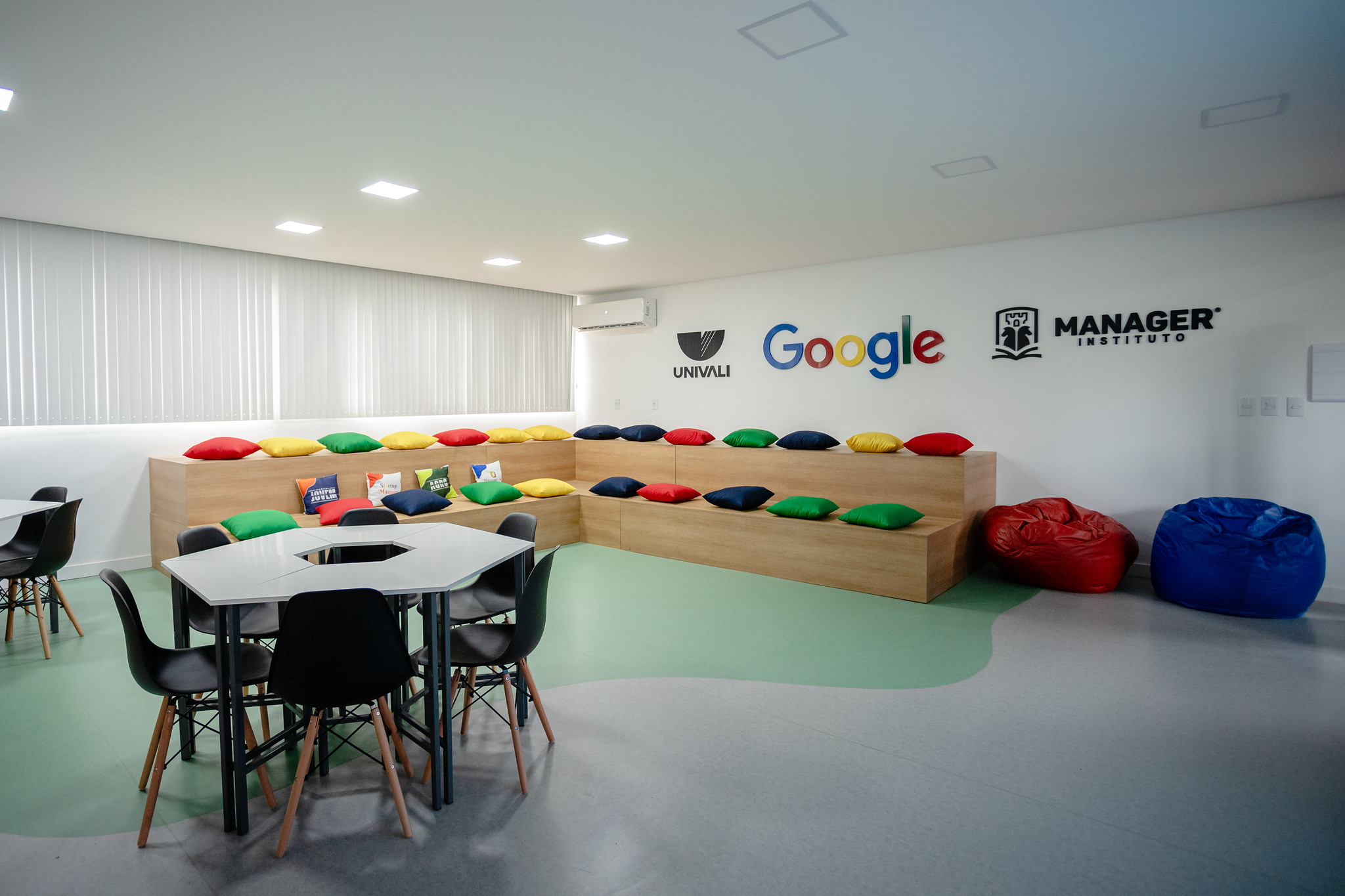 Sala de aula do Instituto Manager com logos Univali, Google e Manager na parede